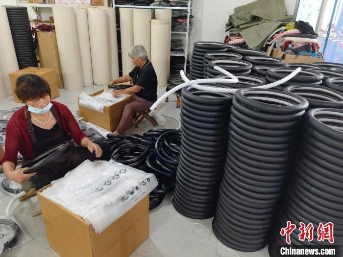 圖為村民在汽車飾品企業(yè)生產(chǎn)車間中工作?！巫雍?攝