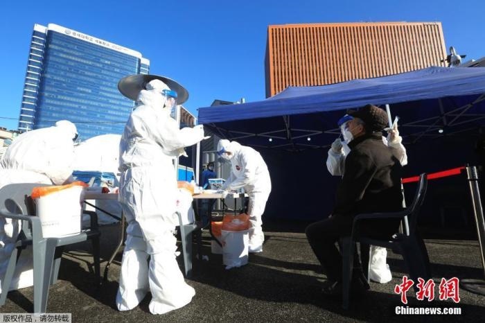 資料圖：韓國首爾，醫(yī)務(wù)人員對市民進(jìn)行新冠病毒檢測。