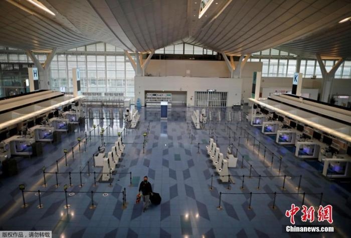 資料圖：日本東京，東京國際機場，一名乘客在國際航班航站樓的登機區(qū)。