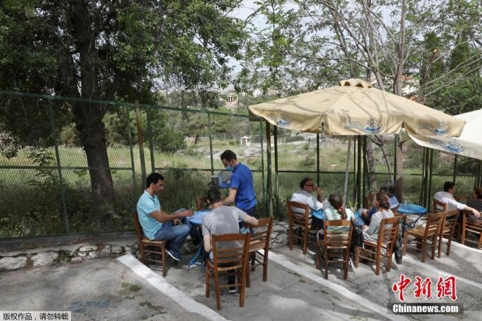 資料圖：希臘雅典，人們在一家露天咖啡享用飲品。