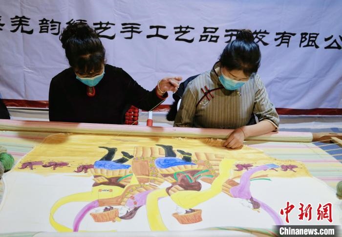 圖為皮繡藝人在市集上“秀”指尖技藝?！●R銘言 攝