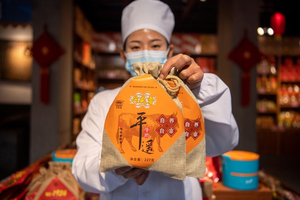 1月27日，在平遙古城南大街的一家平遙牛肉店內(nèi)，工作人員展示一款牛肉產(chǎn)品。新華社記者 楊晨光 攝