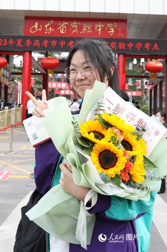 6月7日高考首日，山東67萬考生走進考場，拼搏逐夢。在山東省實驗中學(xué)考點，考生進考場前手捧向日葵花拍照留念，寓意“一舉奪魁”。人民網(wǎng)記者 劉祺攝