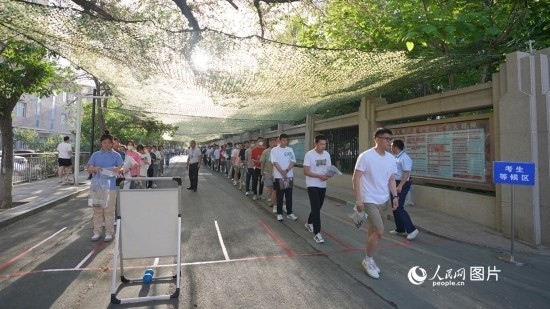 6月7日，烏魯木齊市第七十中學(xué)門口，考生們有序進入考場。人民網(wǎng) 李欣洋攝