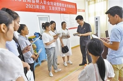  圖③：法院干警現(xiàn)場指導(dǎo)鄉(xiāng)村“代理家長”如何正確管護留守兒童。