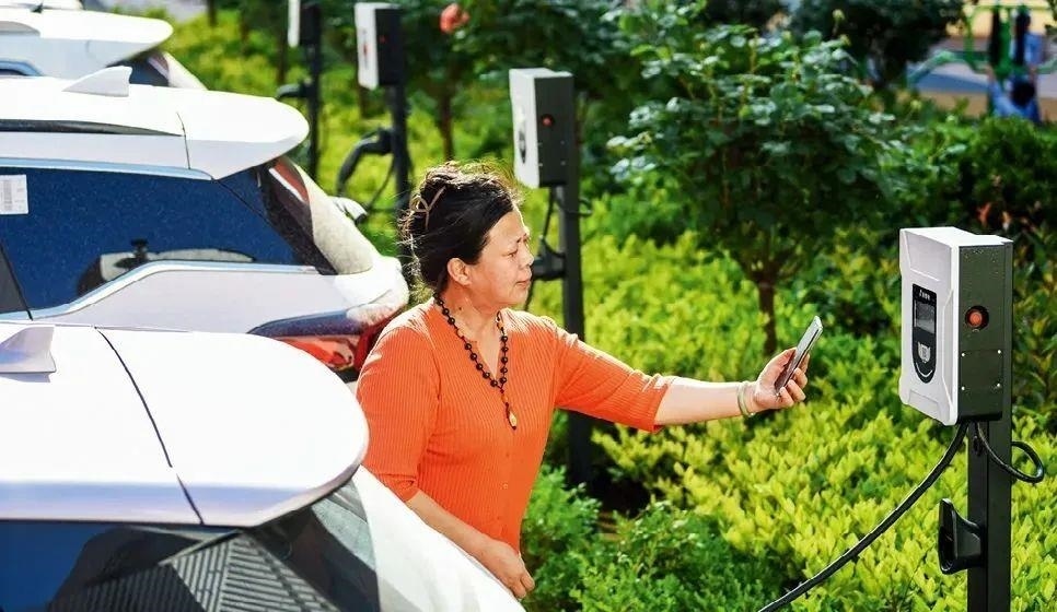 2023年5月24日，山東省膠州市新立街小區(qū)內(nèi)一位居民使用電動汽車充電樁掃碼充電。該小區(qū)加裝各類智慧設(shè)備，打造“智慧社區(qū)”，為居民生活帶來便利。