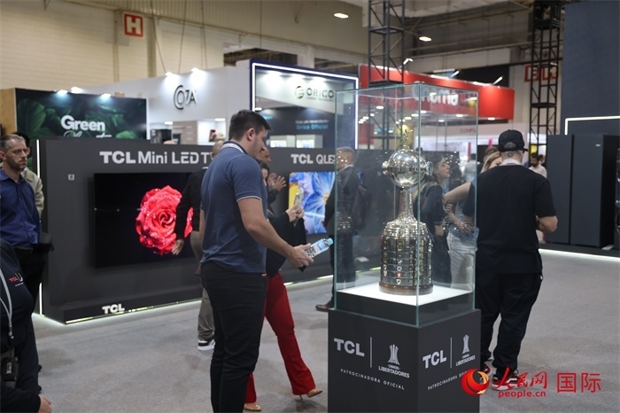 參觀者在TCL展臺(tái)前觀看南美解放者杯獎(jiǎng)杯，據(jù)介紹，TCL是南美解放者杯（2023—2026賽季）全球官方合作伙伴。（人民網(wǎng)記者 時(shí)元皓攝）