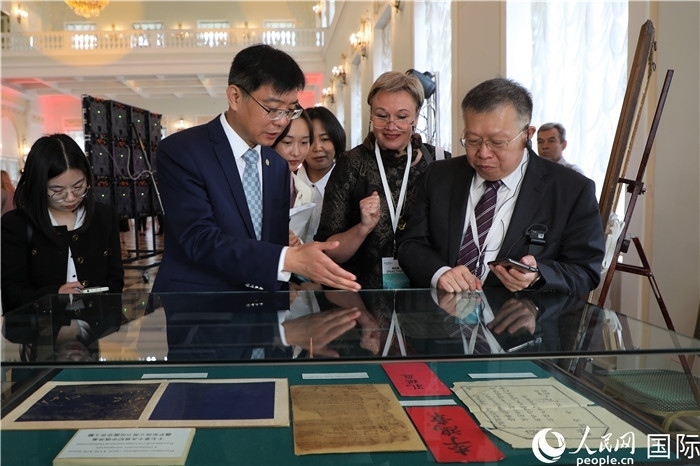 中俄圖書館論壇嘉賓共同參觀由俄羅斯國立列寧圖書館舉辦的館藏中國古籍善本圖書展。人民網記者 隋鑫攝）