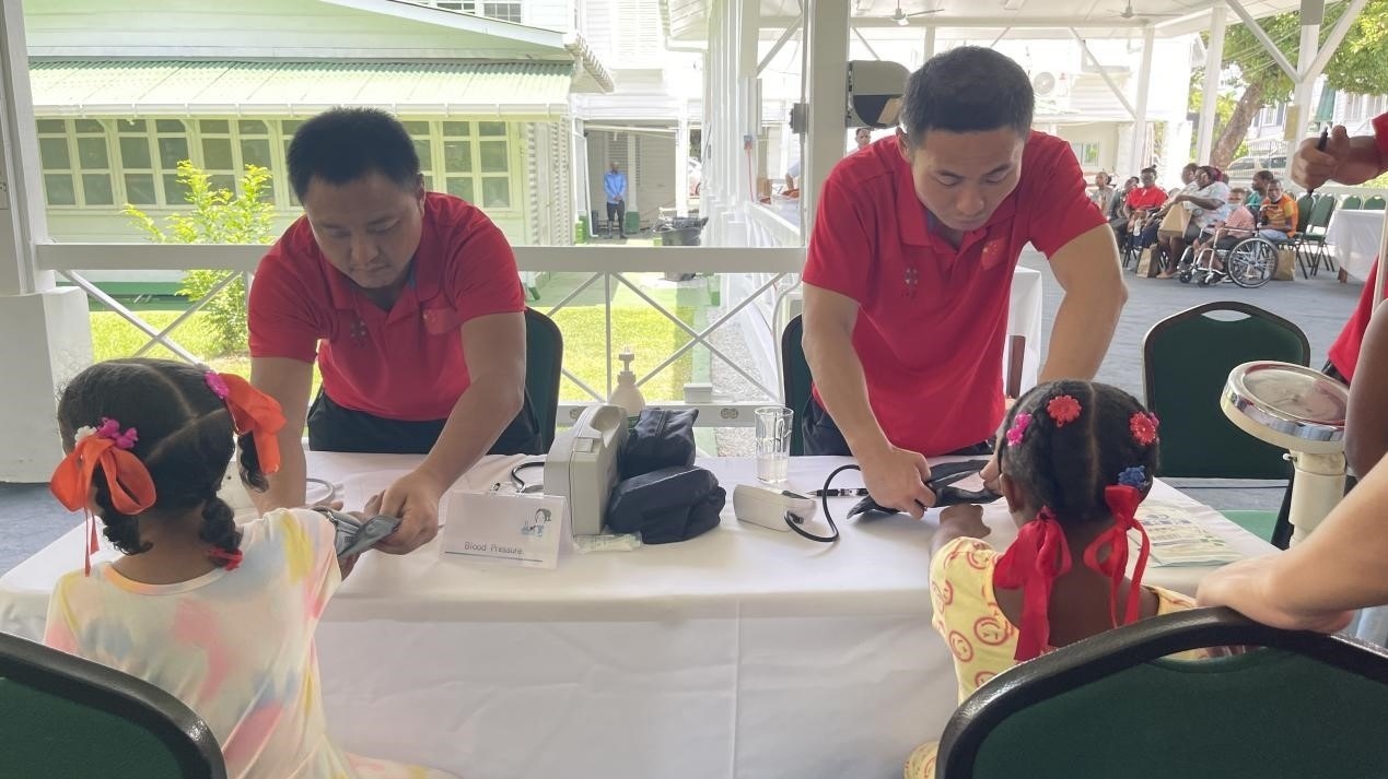醫(yī)療隊(duì)員為福利院兒童進(jìn)行檢查。第18期援圭亞那醫(yī)療隊(duì)供圖