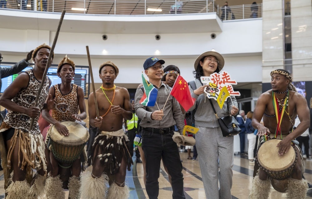 在南非約翰內(nèi)斯堡坦博國際機(jī)場，南非舞蹈演員歡迎中國試點(diǎn)恢復(fù)出境團(tuán)隊(duì)旅游后首批抵達(dá)南非的中國游客（2023年3月29日攝）。