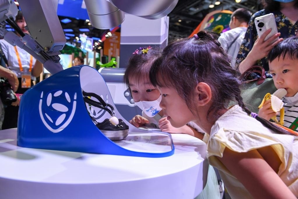9月3日，幾名小朋友在國家會議中心觀看單孔腔鏡手術(shù)機器人展示。新華社記者 鞠煥宗 攝