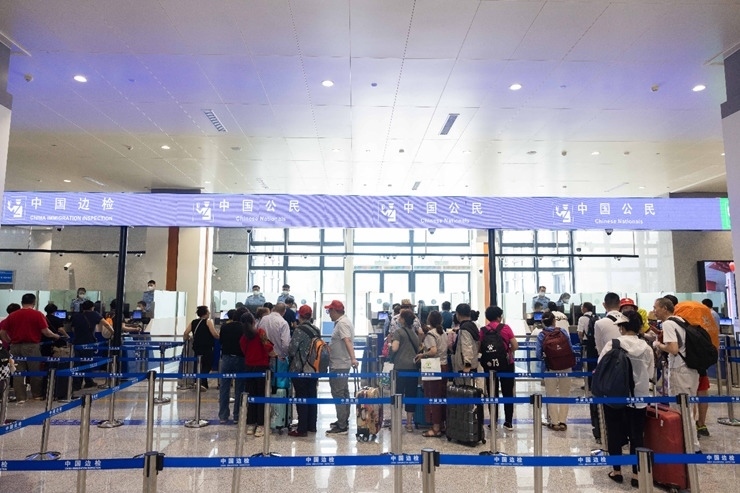 乘坐中老鐵路國際旅客列車的旅客在磨憨邊檢大廳排隊候檢。黃遠飛 攝