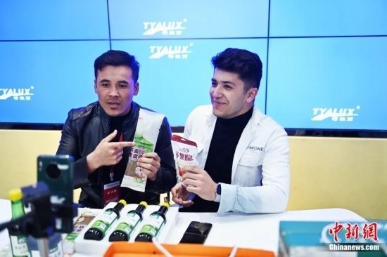 2023年3月，甘肅省慶陽市環(huán)縣電商創(chuàng)業(yè)孵化基地內(nèi)，來自蘭州文理學(xué)院的塔吉克斯坦留學(xué)生正在協(xié)助主播直播帶貨當(dāng)?shù)剞r(nóng)特產(chǎn)品。李亞龍 攝