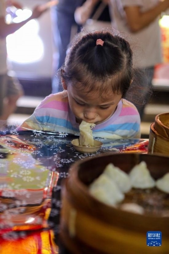 9月27日，小朋友在南翔小籠長街宴上品嘗南翔小籠。