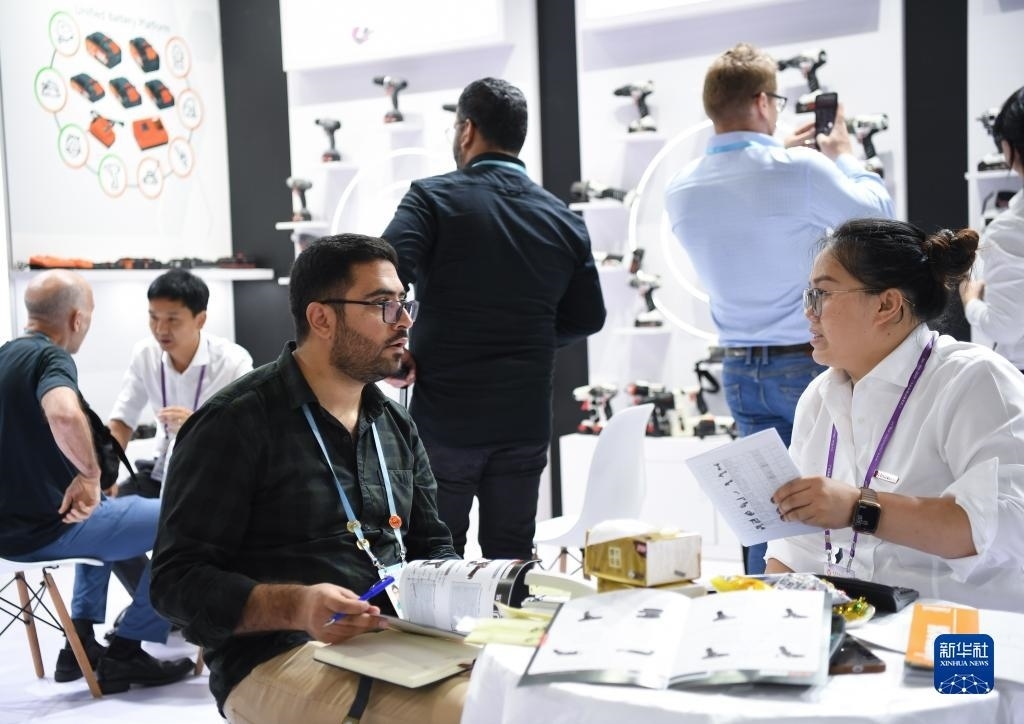 10月15日，在一家電動工具展臺，外國采購商在洽談業(yè)務(wù)。新華社記者 鄧華 攝