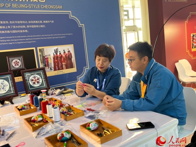 記者在新聞中心非遺傳承人展區(qū)進行體驗。人民網(wǎng)記者 杜燕飛攝