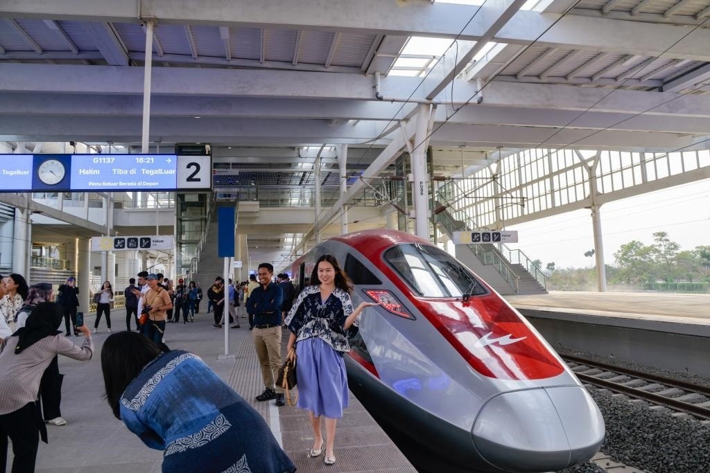 10月17日，在印度尼西亞萬(wàn)隆德卡魯爾站，乘客在站臺(tái)上和雅萬(wàn)高鐵高速動(dòng)車組列車合影。