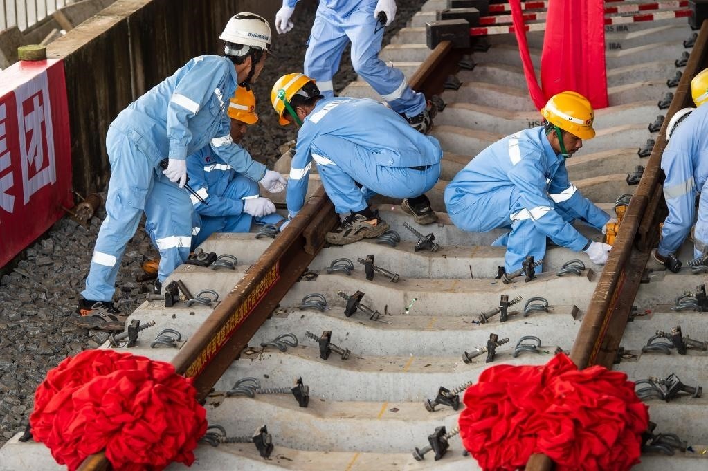 3月31日，在印度尼西亞雅加達(dá)雅萬(wàn)高鐵哈利姆車站，工人鋪設(shè)雅萬(wàn)高鐵全線最后一根鋼軌。