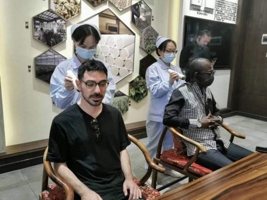 2023“一帶一路”媒體合作論壇聯(lián)合采訪團(tuán)團(tuán)員在九牛草展示館體驗(yàn)艾灸。（本報記者 黃超攝）
