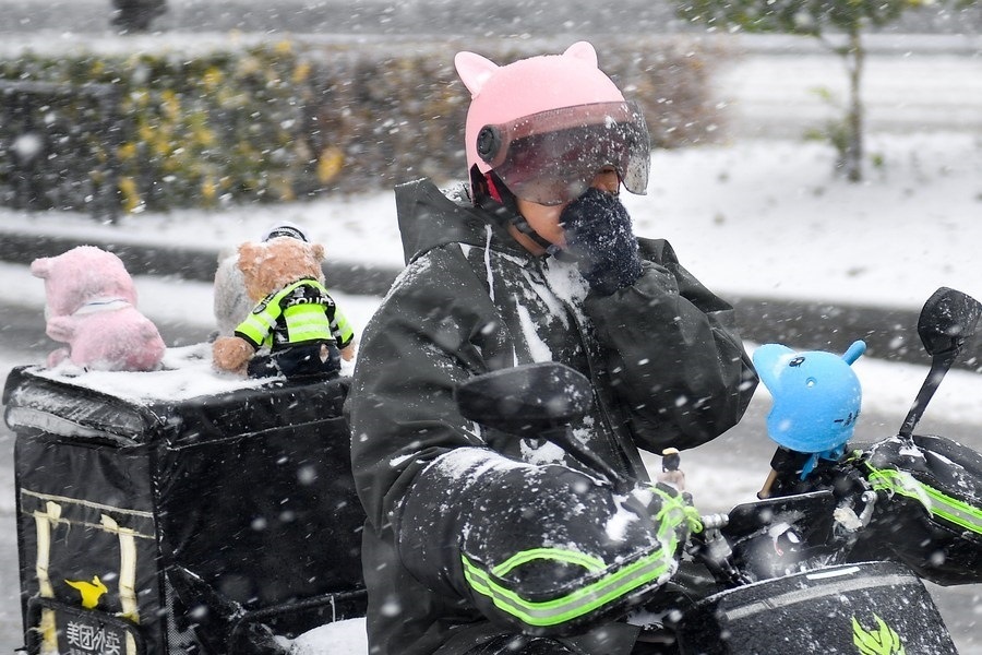 11月6日，在長春市街頭，一名外賣員在雪中騎行。新華社記者 許暢 攝