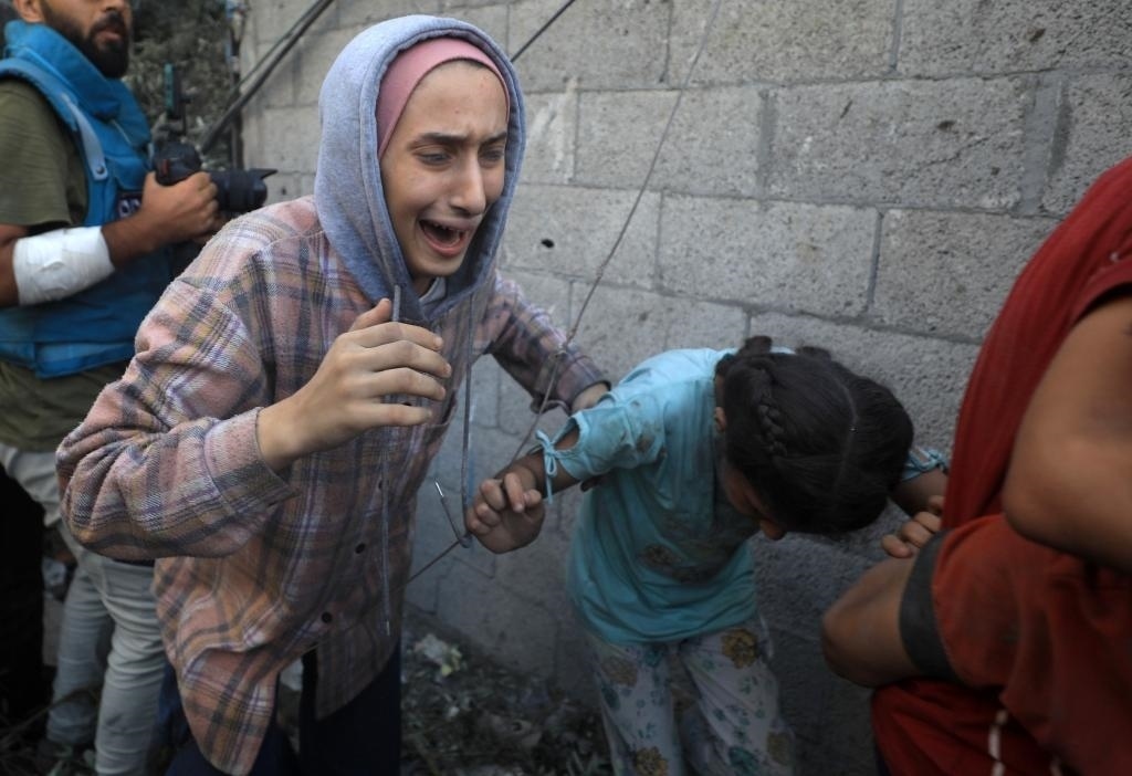 11月6日，人們從加沙地帶中部地區(qū)一處被炸難民營逃離。新華社發(fā)（亞西爾·庫迪攝）