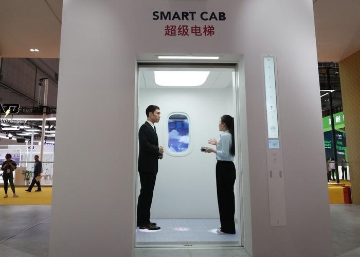 11月5日，工作人員（右）在第六屆進(jìn)博會(huì)上向參觀者介紹奧的斯公司全新推出的超級(jí)電梯。