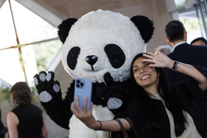 2022年8月24日，在美國華盛頓中國駐美國大使館，來賓與大熊貓玩偶合影。
