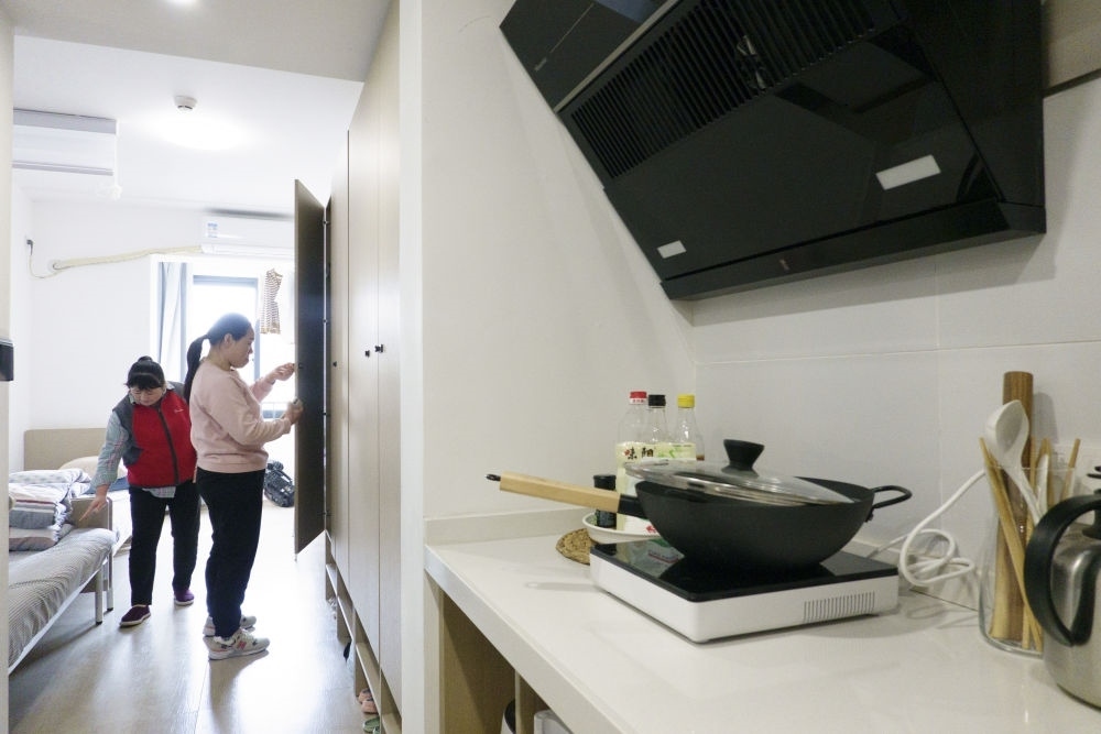 住戶在閔行區(qū)新時代城市建設(shè)者管理者之家收拾房間。