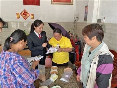  圖⑤：龍圩區(qū)法院法官到群眾家中開展法治宣傳。資料圖片