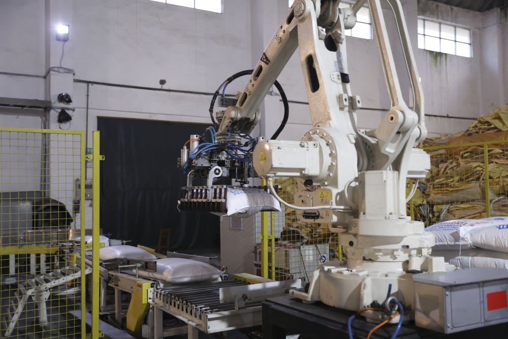 12月14日，在廣西來(lái)賓東糖鳳凰有限公司，機(jī)械臂在廠(chǎng)房碼放白砂糖成品。