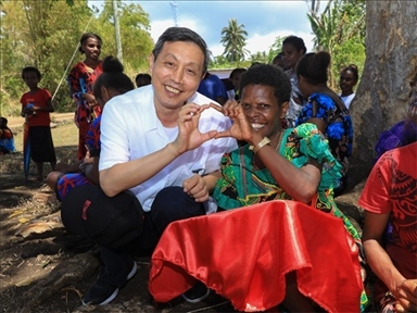 2023年12月18日，中國駐瓦努阿圖大使李名剛和前來觀看瓦努阿圖公路項(xiàng)目二期馬勒庫拉段移交儀式的當(dāng)?shù)鼐用窈嫌?。人民網(wǎng) 賀吉攝