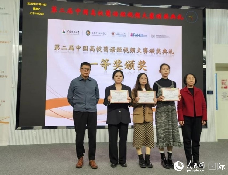 澳門大學中葡雙語教學暨培訓中心主任姚京明（左一）和中國傳媒大學外國語言文化學院院長文春英（右一）為一等獎獲得者頒獎。人民網記者 魯揚攝