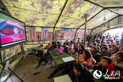 12月22日，在積石山縣大河家鎮(zhèn)大河村安置點(diǎn)，陸軍76集團(tuán)軍某旅搭建的“臨時(shí)學(xué)?！眱?nèi)，小朋友正在看動(dòng)畫片。人民網(wǎng)記者 翁奇羽攝