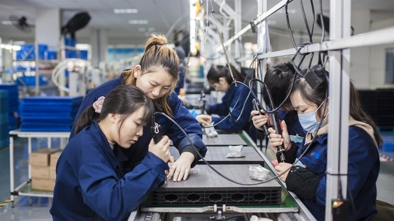 在新亞勝光電的產(chǎn)品線上，工人正進(jìn)行產(chǎn)品組建和安裝布線。受訪者供圖
