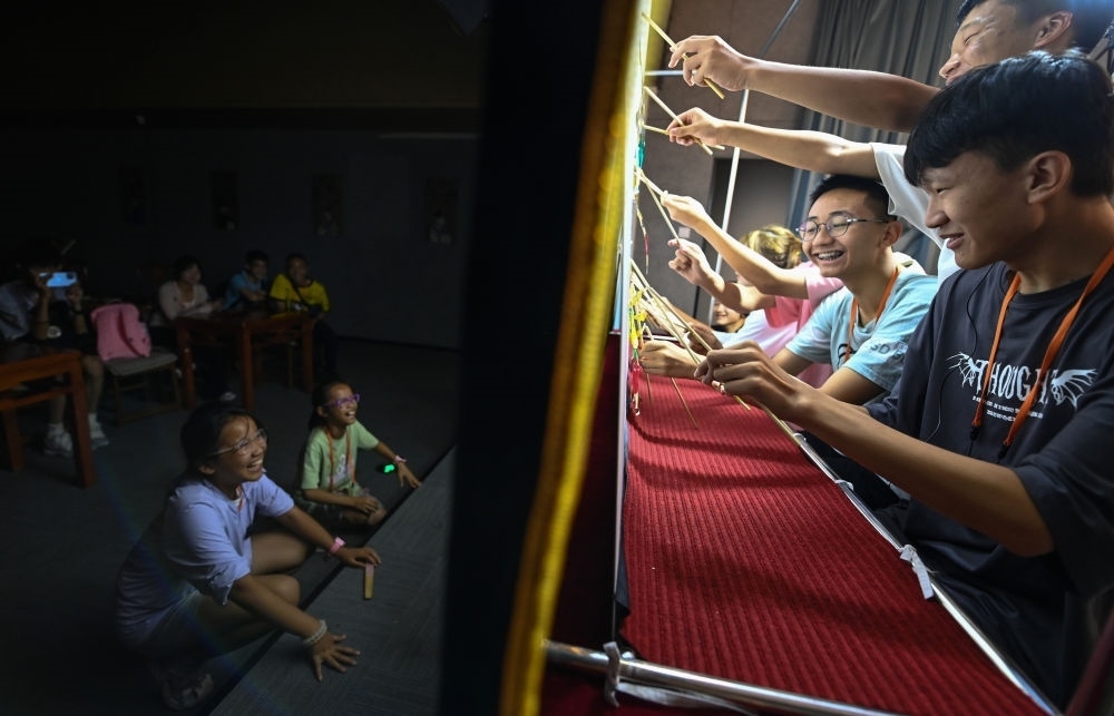 2023年8月8日，進(jìn)行暑期研學(xué)的學(xué)生在位于陜西省西安市的中國秦腔藝術(shù)博物館體驗(yàn)皮影戲演出。新華社記者 鄒競一 攝