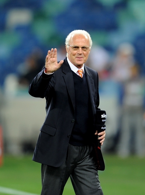 這是2010年7月7日，在南非德班舉行的2010年足球世界杯德國隊(duì)對陣西班牙隊(duì)的半決賽前，貝肯鮑爾接受電視臺(tái)采訪時(shí)和友人打招呼。新華社記者 王毓國 攝