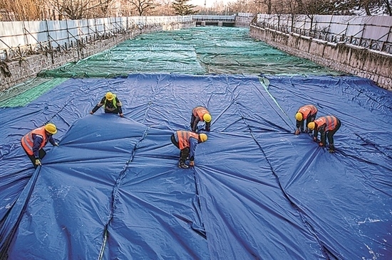 1月3日，房山區(qū)東風(fēng)街道，工人正在修復(fù)的河道內(nèi)給混凝土鋪設(shè)保溫布。