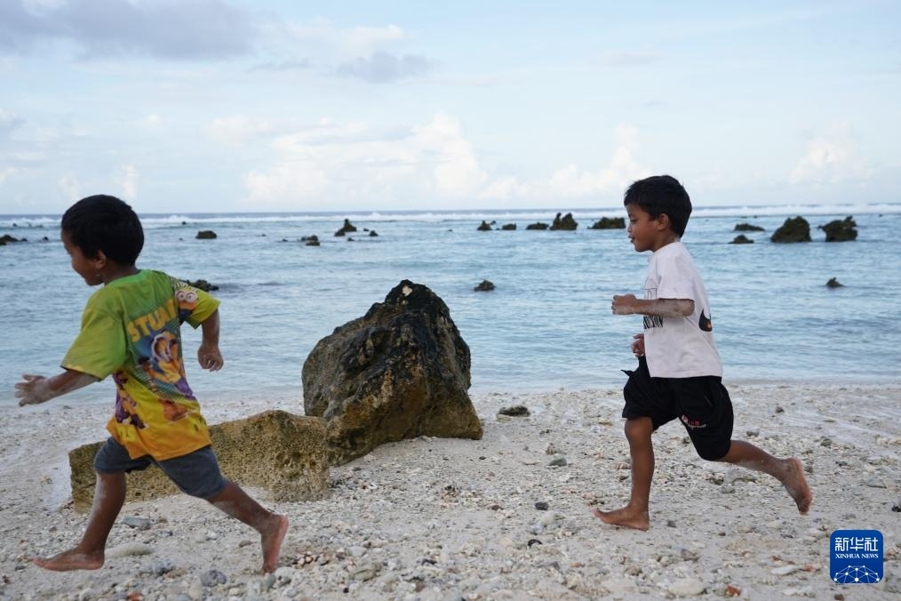 1月20日，兒童在瑙魯海邊嬉戲。新華社記者 王申 攝