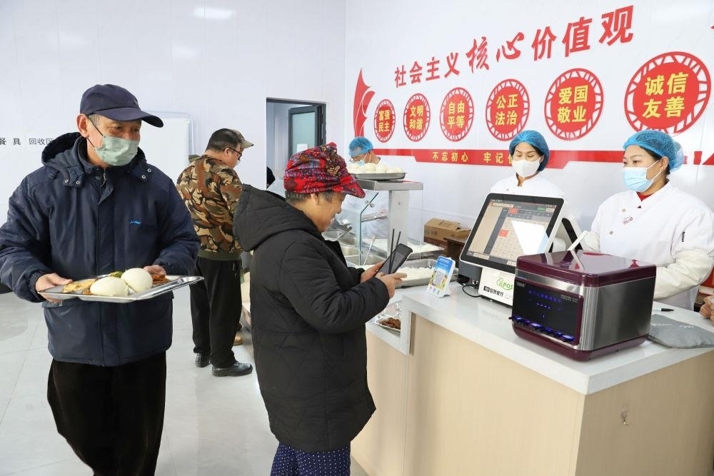 △2024年2月1日，市民在河北涿州市雙塔街道永濟秀園小區(qū)便民食堂內(nèi)購買午餐。