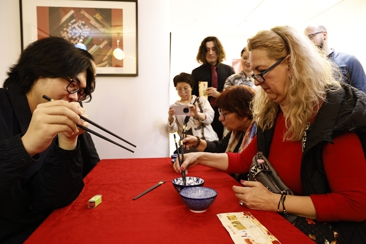 羅馬尼亞觀眾體驗(yàn)用筷子夾花生。中國文化中心供圖