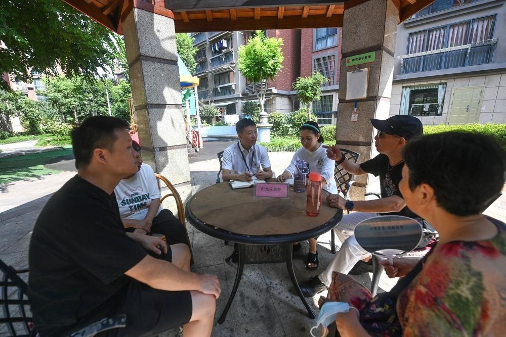 △2023年7月21日，在位于浙江杭州臨安區(qū)錦南街道水岸陽光小區(qū)的陽光議事廳，街道干部在聽取居民們反映的問題及意見。