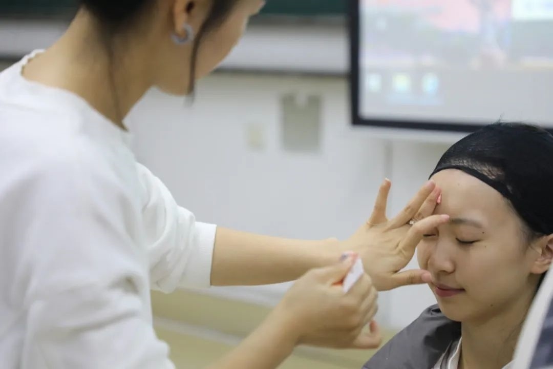 課堂上，一名學生在體驗上戲妝。學校供圖