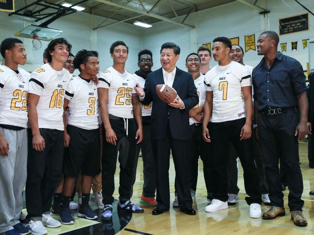 2015年9月23日，國家主席習(xí)近平參觀美國塔科馬市林肯中學(xué)。這是習(xí)近平在學(xué)校體育館，同上橄欖球訓(xùn)練課的學(xué)生們親切交談。新華社記者 蘭紅光 攝