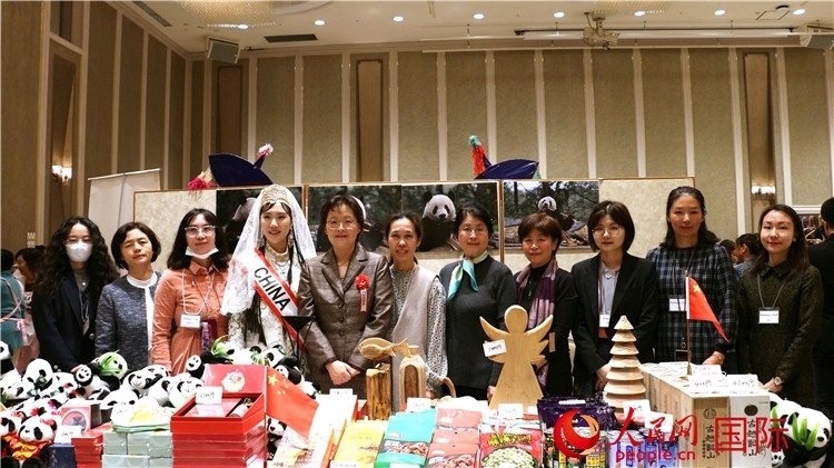 中國駐日本大使吳江浩夫人丁玥（左五）與使館人員在展位前合影留念。人民網(wǎng) 許可攝
