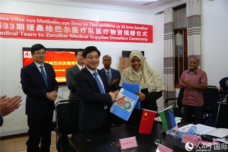 江蘇省蘇北人民醫(yī)院黨委書(shū)記束余聲與桑衛(wèi)生部首席秘書(shū)哈比巴交換捐贈(zèng)書(shū)。中國(guó)援桑醫(yī)療隊(duì)供圖