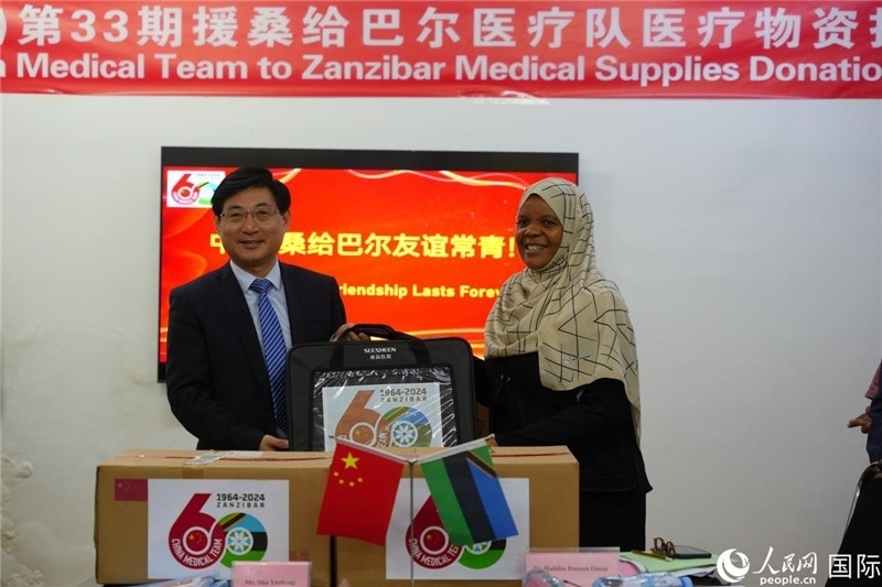 江蘇省蘇北人民醫(yī)院黨委書(shū)記束余聲捐贈(zèng)物資與桑衛(wèi)生部首席秘書(shū)哈比巴。中國(guó)援桑醫(yī)療隊(duì)供圖