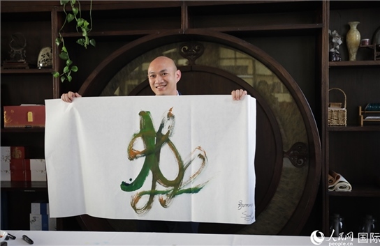 老撾駐華大使館三秘明君參加《五百筆·瀾湄合作》集體藝術(shù)創(chuàng)作。人民網(wǎng)王婧攝。