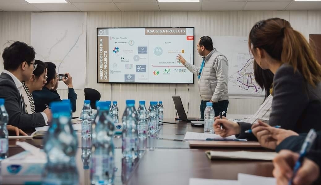 德亞（右三）在和員工開會。中建中東沙特分公司供圖