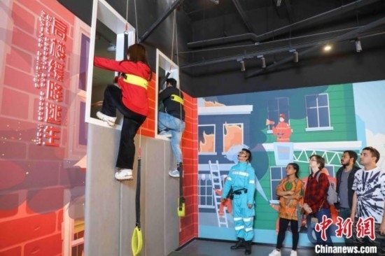 5月9日，留學生體驗模擬高樓緩降逃生。張鷹 攝