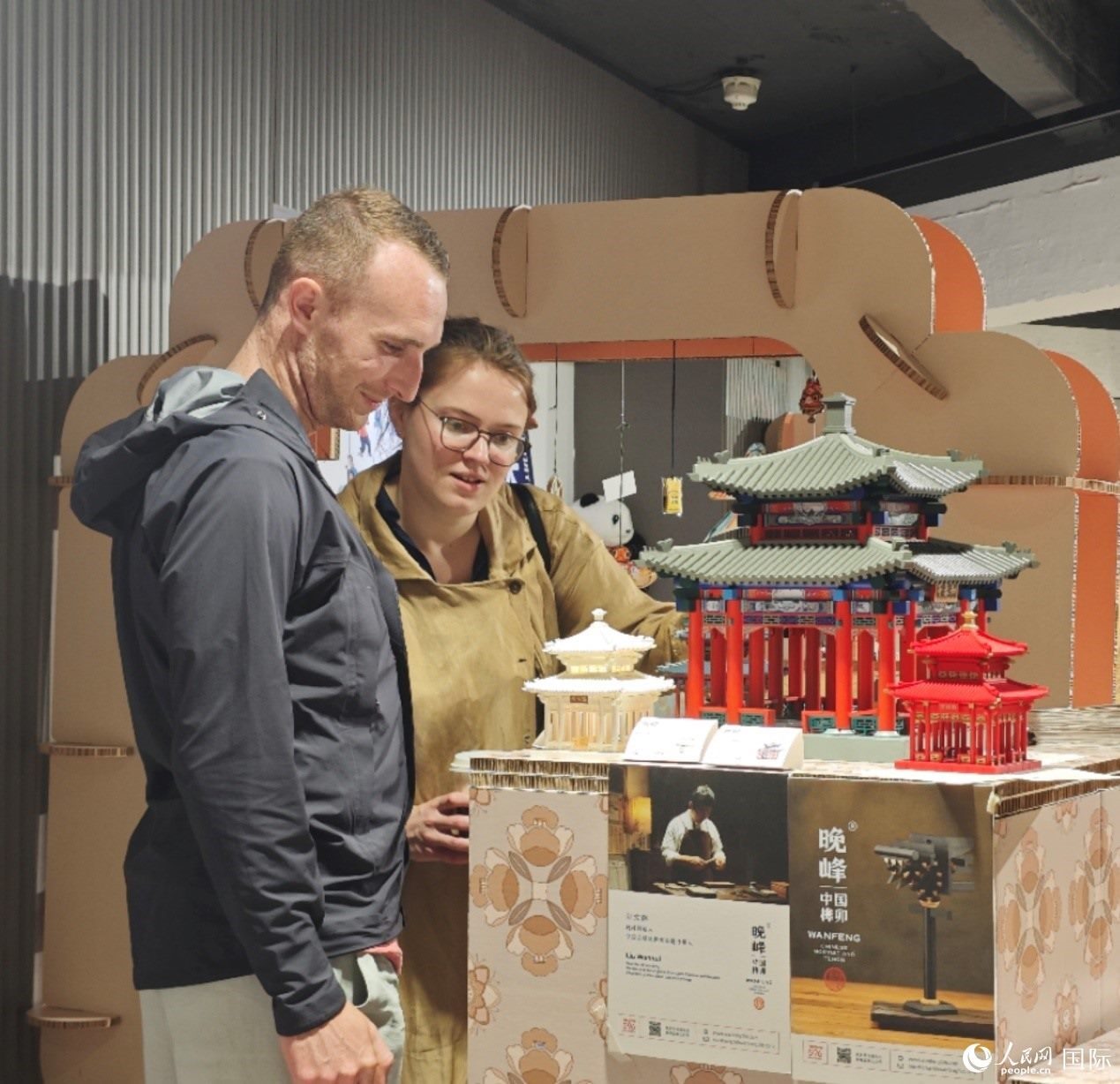 英國觀眾在欣賞中國傳統(tǒng)榫卯結構建筑模型。邢雪攝